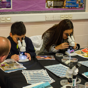 Children looking down a microscope