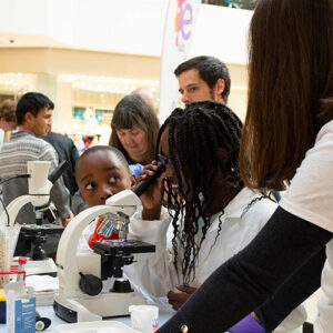 Children looking down a microscope